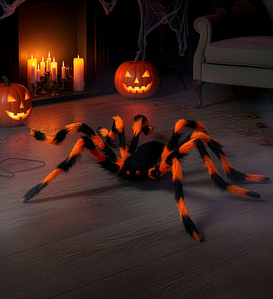 Harige spin zwart-oranje als Halloweendecoratie op de vloer bij lichtgevende pompoenen
