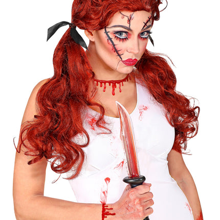 Armband bloeddruppels om de pols bij een witte horrorpop-look voor Halloween