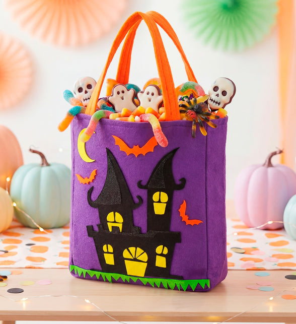 Spookhuis snoeptas gevuld met snoep tussen pompoenen op een Halloweentafel