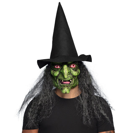 Latex hoofdmasker heks Lucinda met groen gezicht, grijs-zwarte krullen en zwarte punthoed voor Halloween