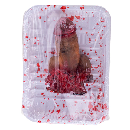 Afgehakte penis op schotel, huidkleurig nepvlees van pvc onder folie met rode bloedspatten, voor Halloween