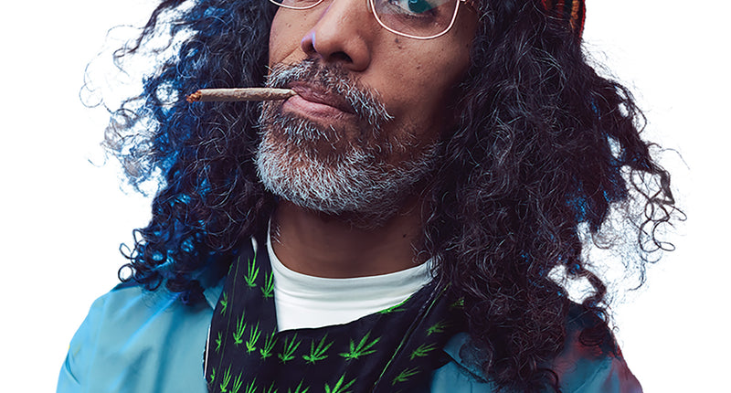 Bandana cannabis zwart met groene bladeren, om de hals gedragen bij een hippielook