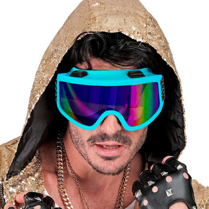 Blauwe feestskibril met regenbooglens bij een gouden glitteroutfit, apres-skilook heren