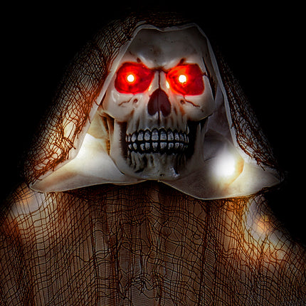 Close-up van de doodskop onder de kap van de grim reaper met licht, met fel rode ledogen in het donker
