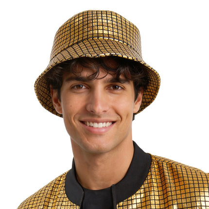 Disco bucket hat goud met holografische blokjes en brede rand, gedragen door een man op een discofeest