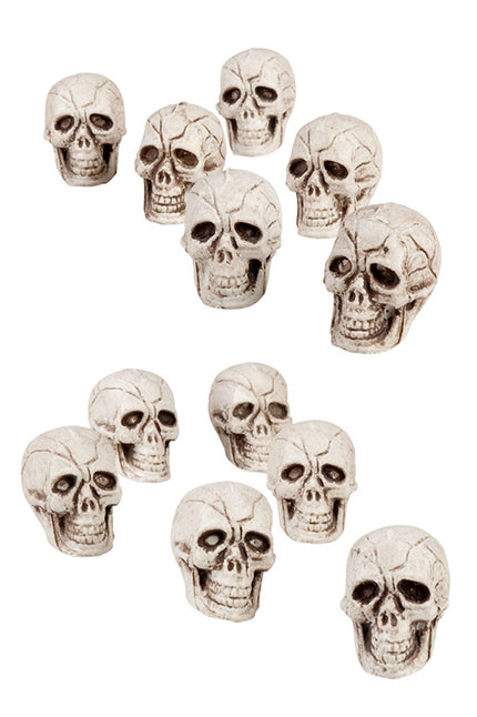 Doodskoppen deco: twaalf witte schedels van 4x3 cm met gebarsten reliëf en open kaak voor Halloween