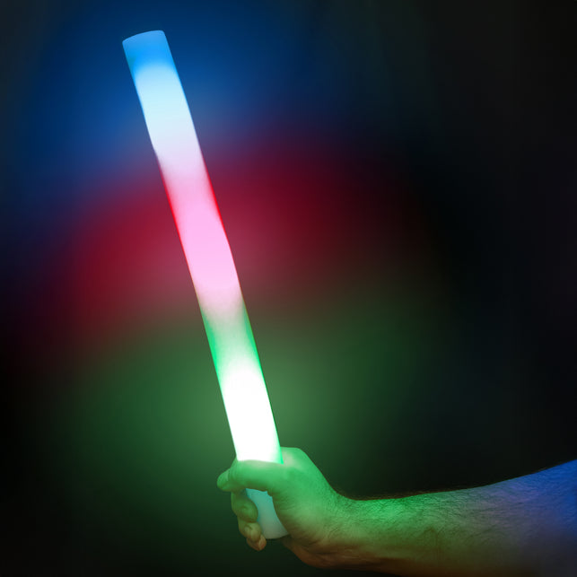 Foam stick led 48 cm in de hand, oplichtend in blauw, rood en groen op een donker feest