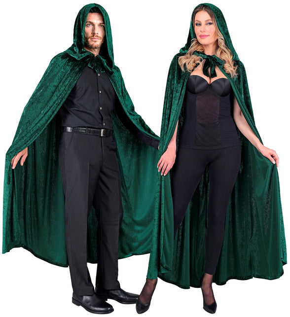 Groene cape met kap over zwarte kleding, met fluwelen strikband in de hals