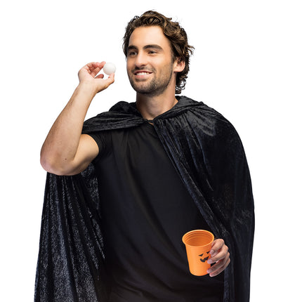 Halloween beer pong met oranje pompoenbeker en wit balletje in de hand tijdens een halloweenfeest