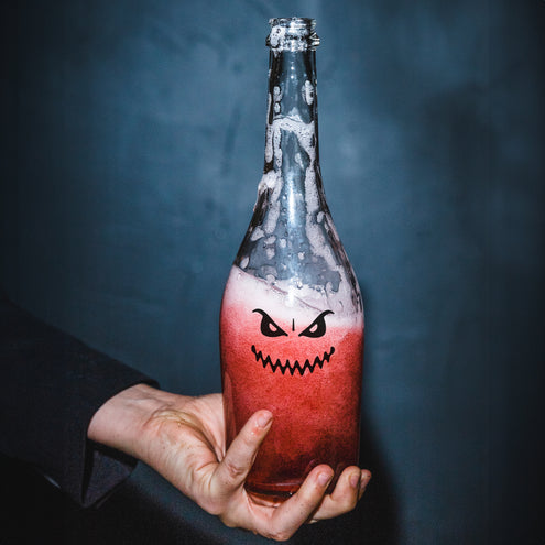 Halloween glassticker met boze ogen en tandenrij op een fles met rood drankje
