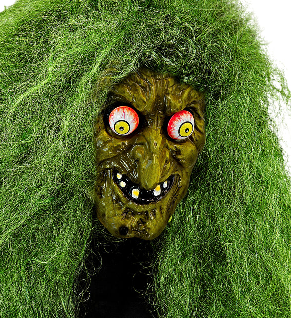 Heksenmasker met wiebelende ogen onder wild groen haar, gerimpeld gezicht met grijns