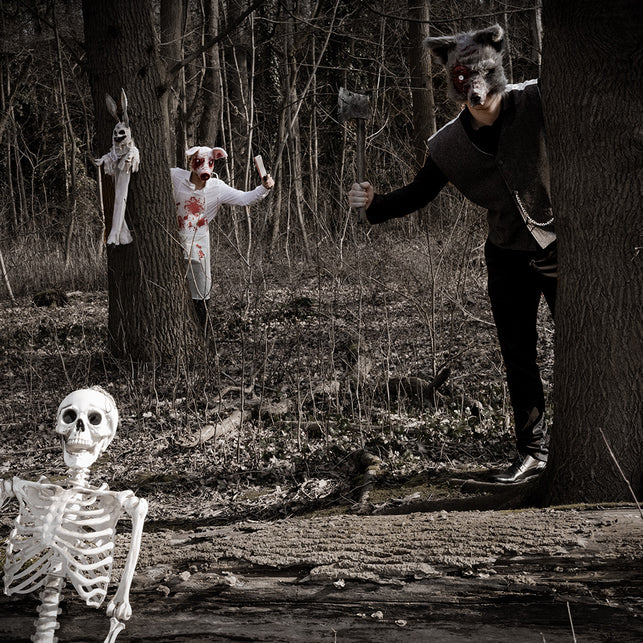Heren met pluchen wolvenmasker in donker bos tijdens Halloween