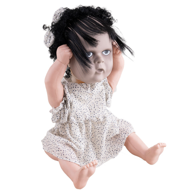 Horrorpop meisje zittend met sluike haarlok over het gezicht, griezelige babypop