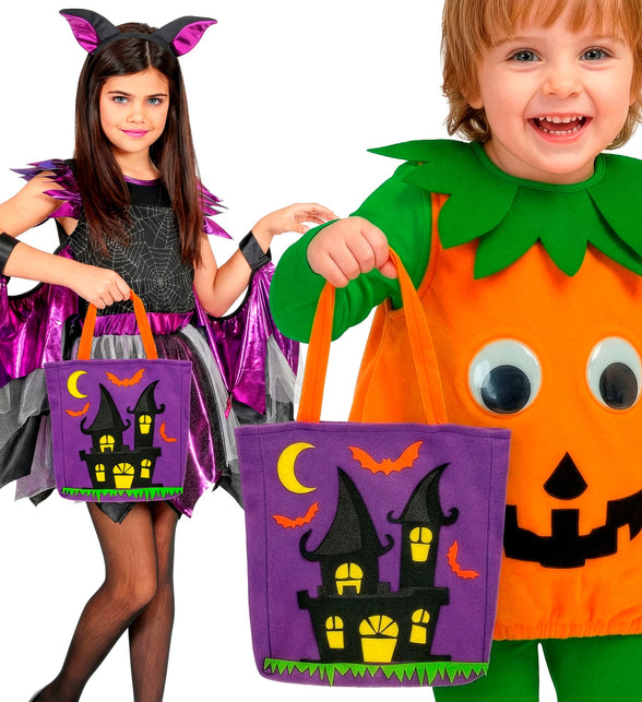 Kinderen met trick-or-treat tas spookhuis bij een vleermuis- en pompoenkostuum op Halloween