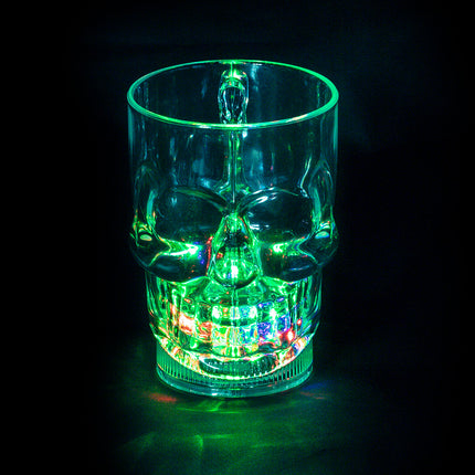 LED beker schedel met groen oplichtende tanden en oogkassen op een halloweentafel