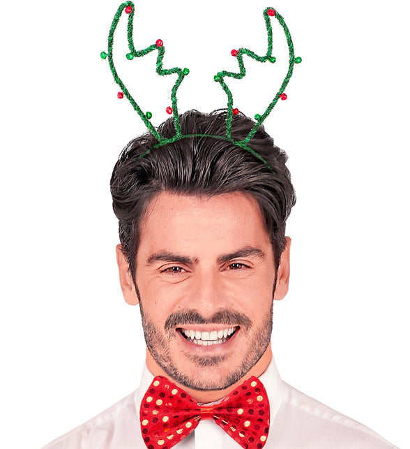 Man met groen rendiergewei op zijn hoofd en rode vlinderdas op een kerstfeest