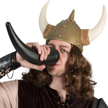 Man met vikinghelm drinkt uit de zwarte drinkbeker hoorn tijdens een vikingfeest