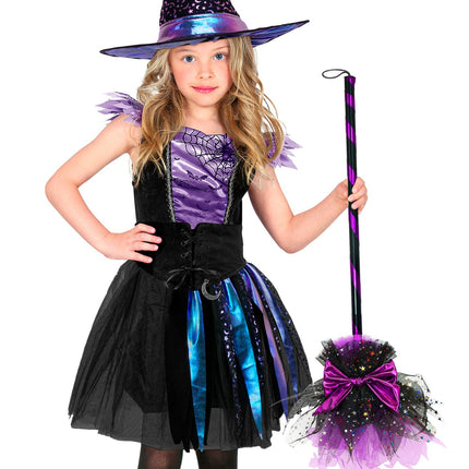 Meisje houdt heksenbezem paars vast bij haar heksenjurk voor Halloween