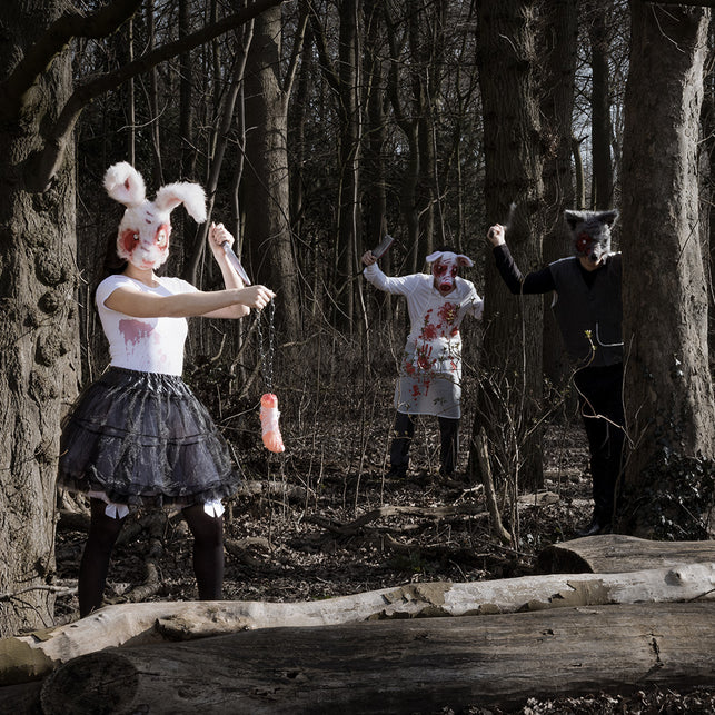 Mes Slasher in de hand van een gemaskerde horrorfiguur in een donker bos tijdens Halloween