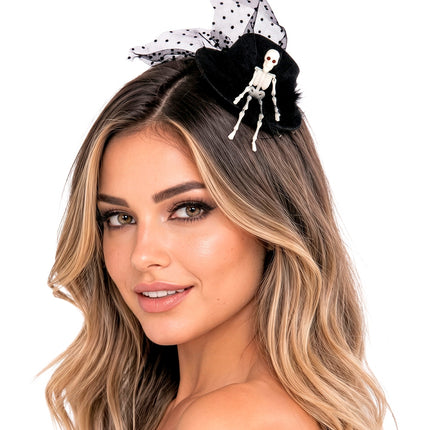 Mini hoge hoed met skelet schuin in het blonde haar gedragen door dame op Halloween