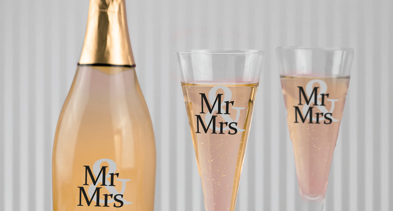 Mr. en Mrs. glasstickers in zwart en grijs op een champagnefles en twee glazen voor een bruiloft