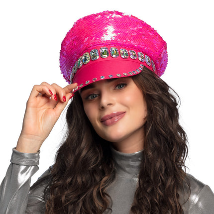 Pailletten pet Sandy candy op een vrouw met lange krullen, hand aan de fuchsia klep met steentjesrand