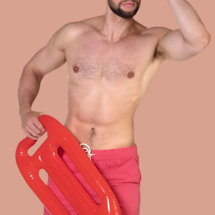 Man met rode opblaasbare reddingsplank aan wit draagkoord bij een strandwachtoutfit