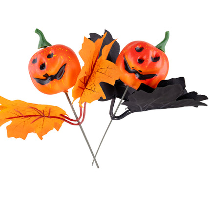 Pompoen takjes met bladeren: twee oranje pompoenkopjes met zwart gezicht op draadsteel met oranje en zwart herfstblad