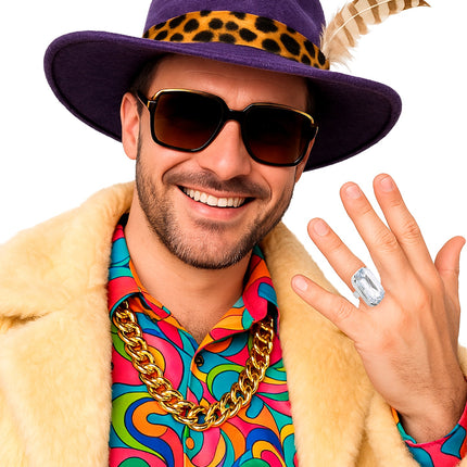 Ring met nep diamant aan de hand van een pimpkostuum met bontjas, steen vult het vingerkootje