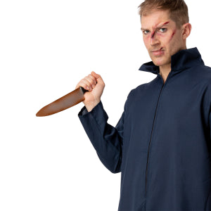 Roestig slagers mes in de hand gehouden bij een donkerblauwe overall op Halloween