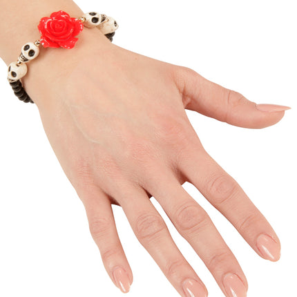 Schedel armband met zwarte kralen, witte doodshoofdjes en rode roos gedragen om de pols