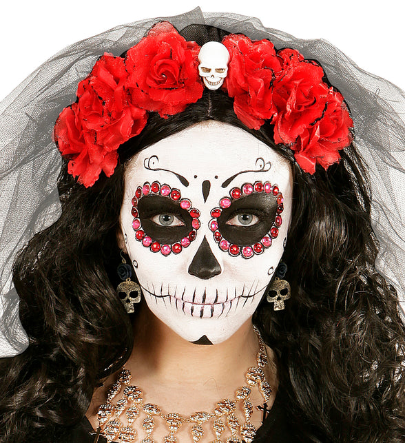 Schedeloorbel met roos gedragen bij witte schedelschmink en rode rozenhaarband voor Halloween