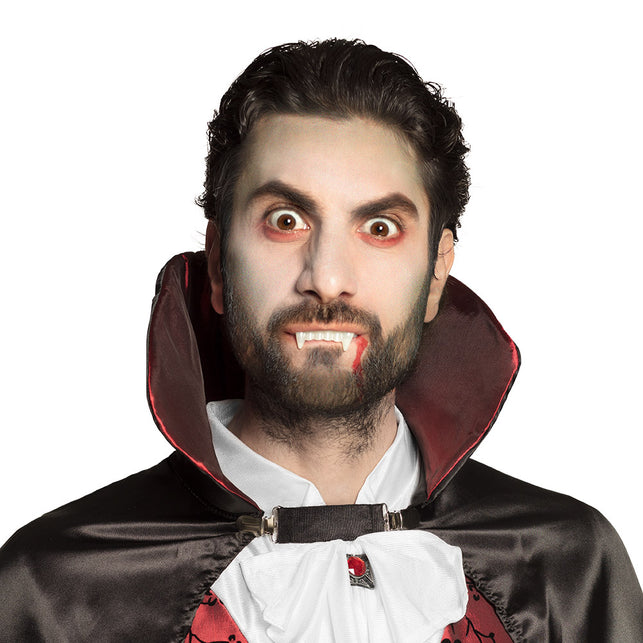 Vampiertanden gedragen met bloedspoor langs de mondhoek voor een Halloween vampierlook