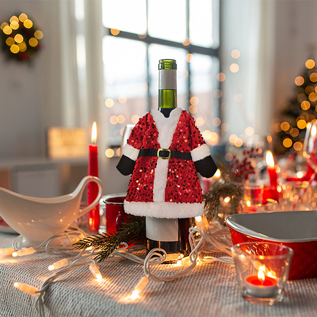 Wijnfles cover Kerstman over een wijnfles op de gedekte kersttafel tijdens het kerstdiner