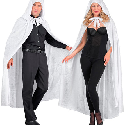 Witte cape met kap over zwarte kleding, striksluiting zichtbaar bij de hals