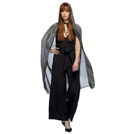 Zilveren cape met capuchon over zwarte jumpsuit bij dames, glanzende stof tot kuithoogte