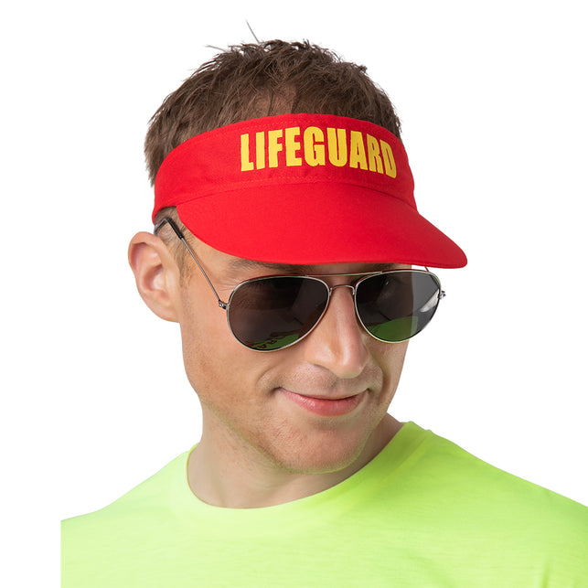 Zonneklep badmeester Bart in het rood met geel opschrift, gedragen door een man op een strandfeest