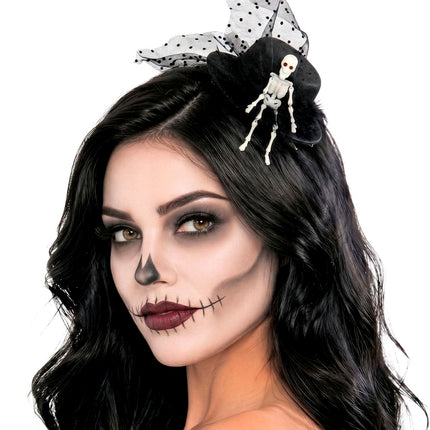 Zwart mini hoedje met skelet bij donker haar en skeletschmink voor een halloweenlook
