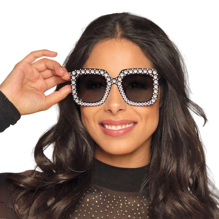 Zwarte bril met strass stenen en grijs getinte glazen, gedragen voor een glamourfeest