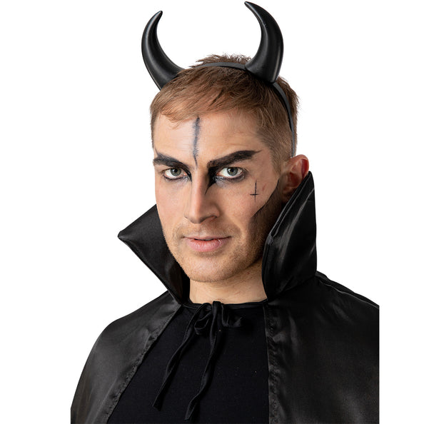 Zwarte duivelhoorntjes diadeem Satan gedragen door man met donkere schmink en zwarte cape voor Halloween