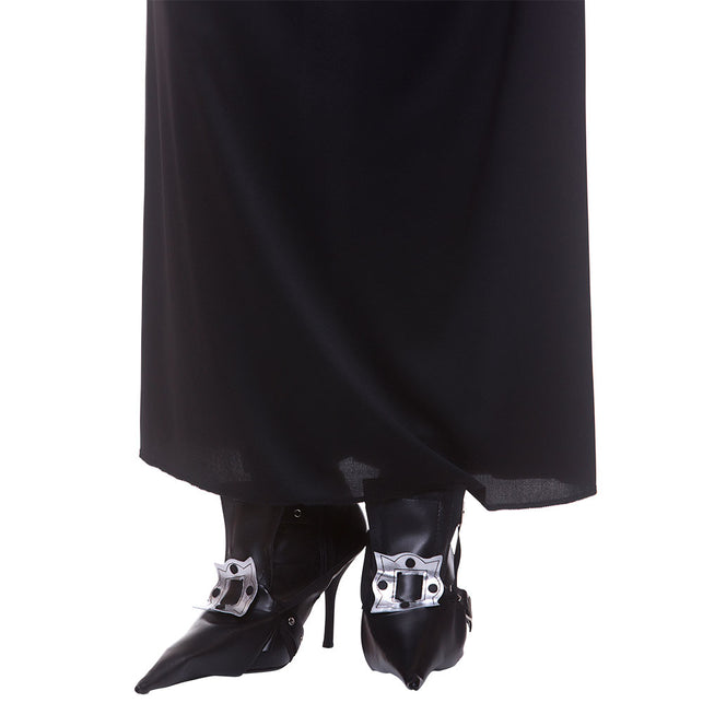 Zwarte laarskappen heks Stella over hakschoenen gedragen, met bandje en zilveren sierplaat, voor Halloween