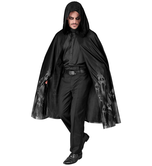 Zwarte spookcape met ruime capuchon en koordje aan de hals, gedragen over zwarte kleding